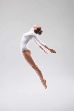 Jumping young gymnast in studioの写真素材