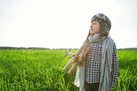 Little boy with wooden airplane outdoorsの写真素材