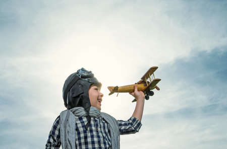 Boy with wooden airplane outdoorsの写真素材