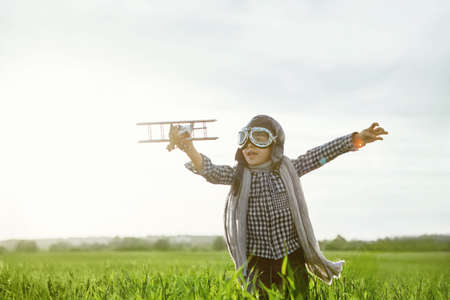 Little boy with wooden airplane outdoors