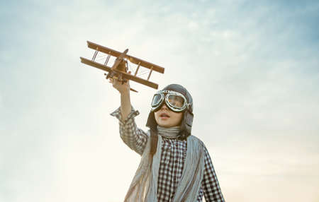 Little boy with wooden airplane outdoorsの写真素材