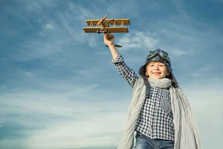 Little boy with wooden airplane outdoors