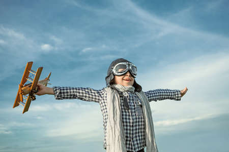 Happy boy with wooden airplaneの写真素材
