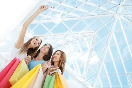Young girls with shopping bags make selfの写真素材