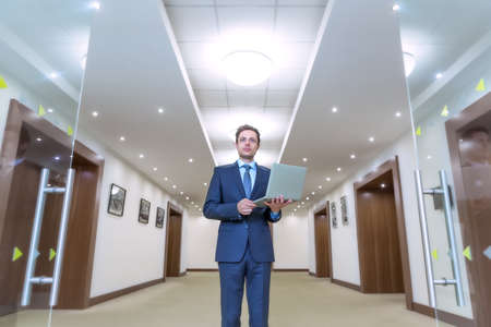 Young business man with laptop indoorsの写真素材