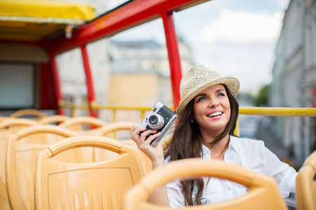 Young girl with retro camera in the tour busの写真素材