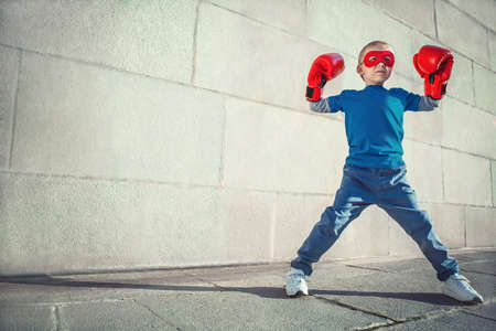 Little boy with boxing gloves outdoorsの写真素材