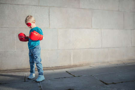 Little boy with boxing gloves outdoorsの写真素材