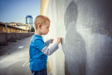 Little boy painting on the wallの写真素材