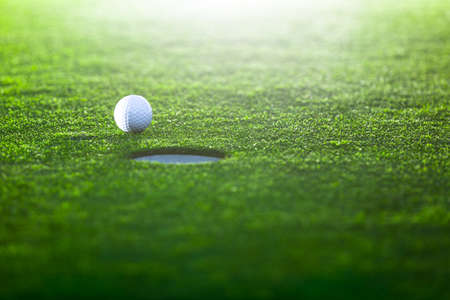 Golf ball on a green lawnの写真素材