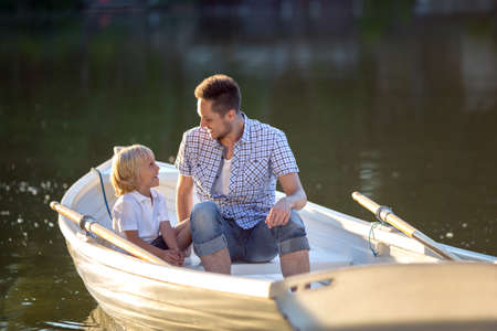 Dad and son in the boatの写真素材
