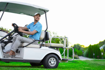 Young golfer on cart outdoorsの写真素材