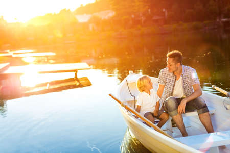 Father and son in boat at sunsetの写真素材
