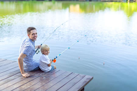 Dad and son fishing in summerの写真素材
