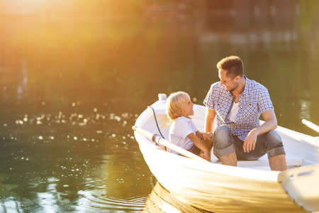 Dad and son in boat on the lakeの写真素材