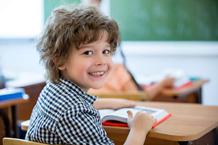 Little boy at a desk in classroom