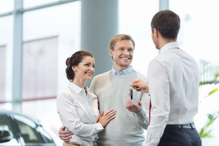 Couple buying a car in autocenterの写真素材