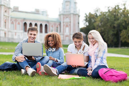 Young student with laptop outdoors