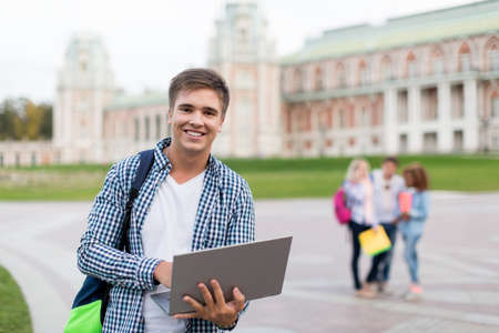 Young man with laptop in parkの写真素材