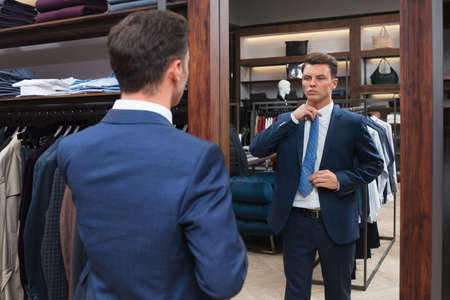 Young businessman at a mirror