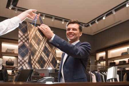 Young businessman with bag in storeの写真素材