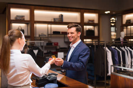 Young businessman with seller at checkoutの写真素材