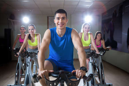 Smiling people on cycle indoors