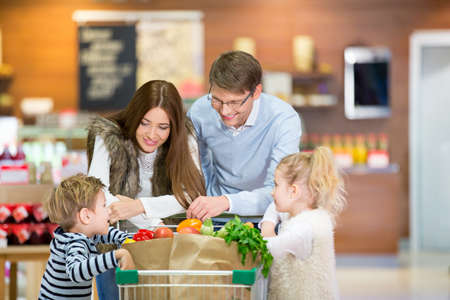 Smiling family with shopping cartの写真素材