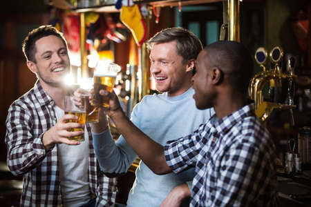 Smiling man with a beer at a bar