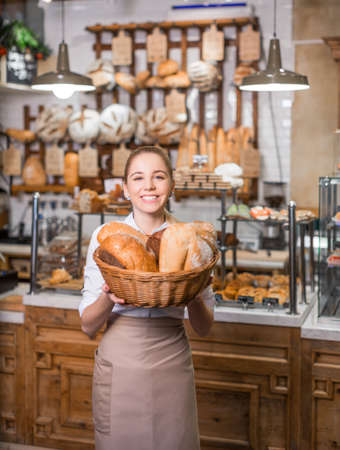Young baker with a basket of breadの写真素材