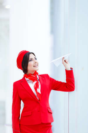 Happy stewardess with a paper airplaneの写真素材