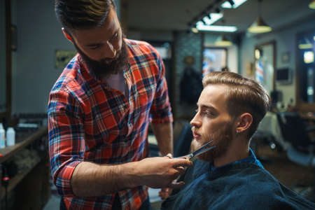 Young bearded man in a barber shopの写真素材