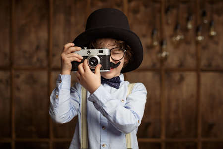 Little hipster with camera in studio