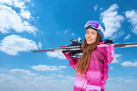 Smiling woman with skis outdoorsの写真素材