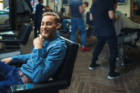 Smiling young man in barber shopの写真素材