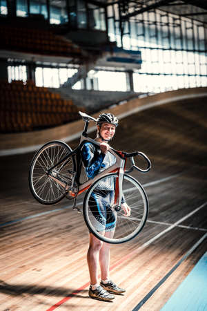 Athlete with a bicycle on velodrome