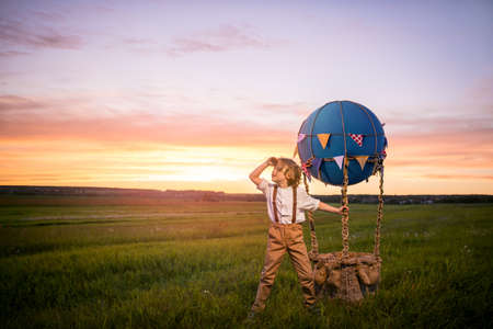 Little boy with aerostat in the fieldの写真素材
