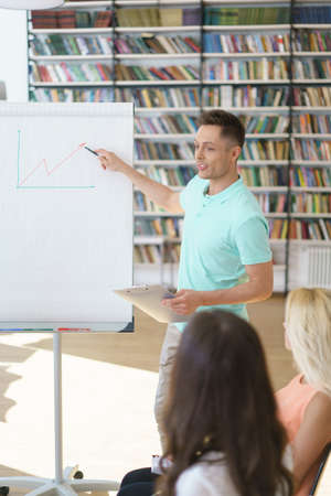 Young coach with a flipchartの写真素材