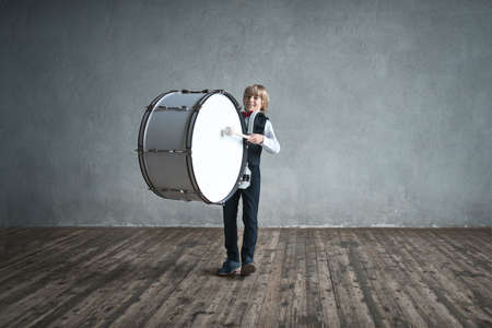 Boy playing a drum indoorsの写真素材