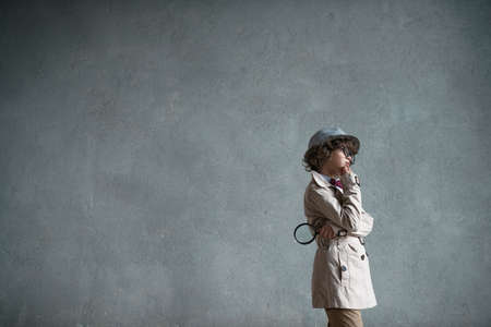 Detective with a magnifying glass in studioの写真素材