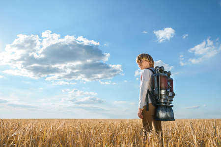 Boy with a backpack in wheat fieldの写真素材