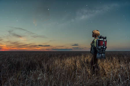 Little boy with a backpack at nightの写真素材