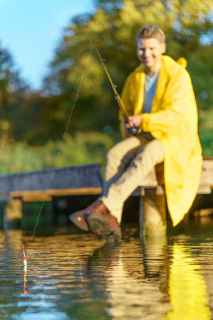Man in yellow raincoats fishing