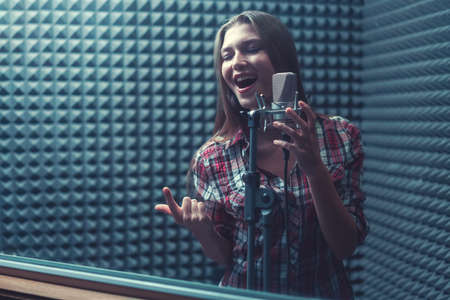 Happy woman singing indoorsの写真素材