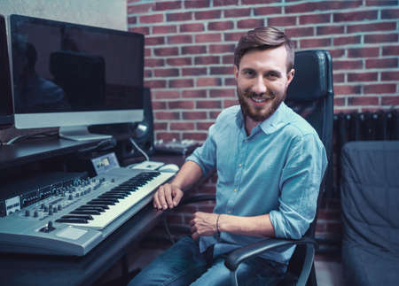 Smiling producer in recording studioの写真素材