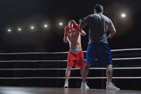 Fighting men in a boxing ringの写真素材