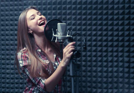 Young singer in a recording studioの写真素材