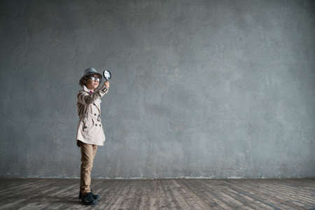 Little boy with a magnifying glass in studioの写真素材