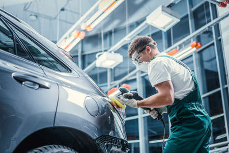 Young man polishing car in service