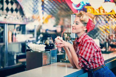 Pin-up girl with milkshake indoorsの写真素材